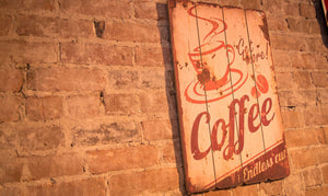 sign on brick wall saying Get More Coffee