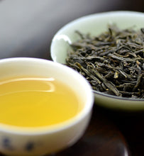 brewed green tea beside green tea leaves