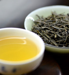 brewed green tea beside green tea leaves