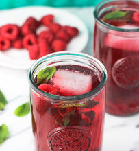 iced raspberry green tea beside red raspberries