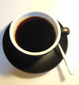 black coffee in a white coffee cup with black saucer