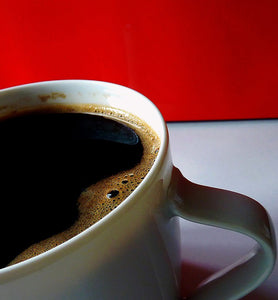 black coffee in white porcelain cup with red background