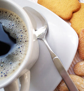black coffee in white coffee mug beside cookies