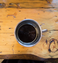 black coffee in silver coffee cup on wooden table