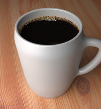 black coffee in white coffee mug on wooden table