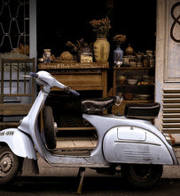 a silver scooter parked outside a store