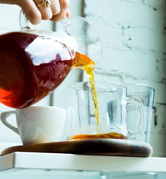 Tea Pouring. Tea Being Poured Into Glass Transparent Tea Cup. Tea