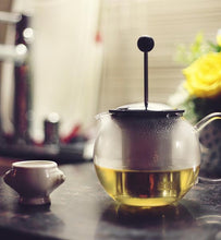 green tea brewing in clear glass teapot