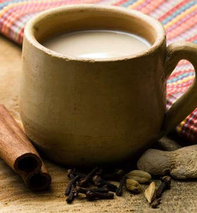 masala chai in brown cup beside spices